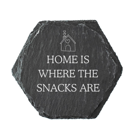 Hexagonal black slate coaster with 'Home is where the snacks are' text on a white background