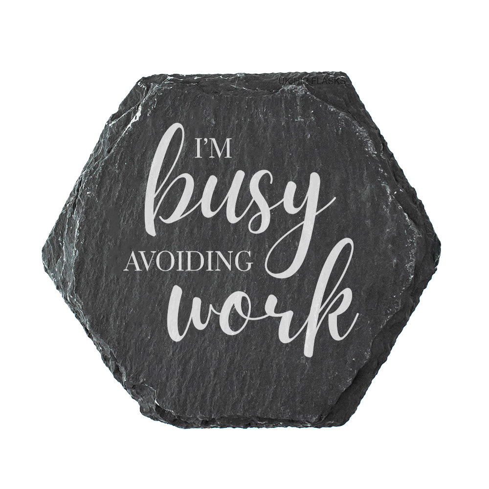 Hexagonal black slate coaster with 'I'm busy avoiding work' text on a white background