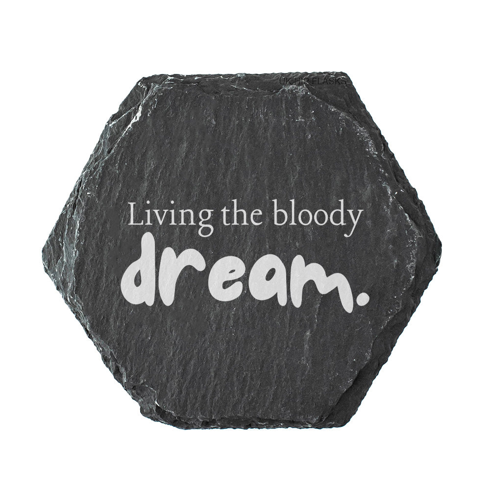 Hexagonal black slate coaster with 'Living the bloody dream.' text on a white background