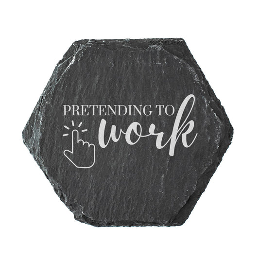 Hexagonal black slate coaster with 'Pretending to work' text and cursor icon on a white background