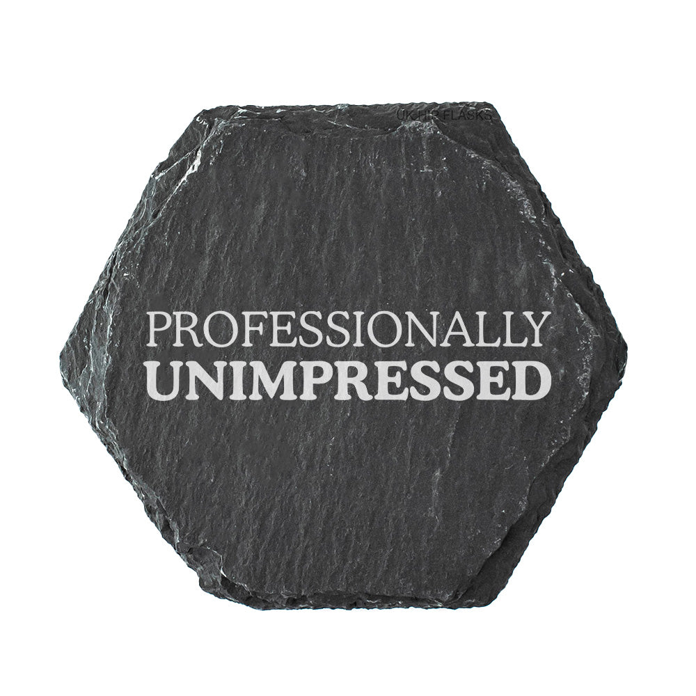 Hexagonal black slate coaster with 'PROFESSIONALLY UNIMPRESSED' text on a white background