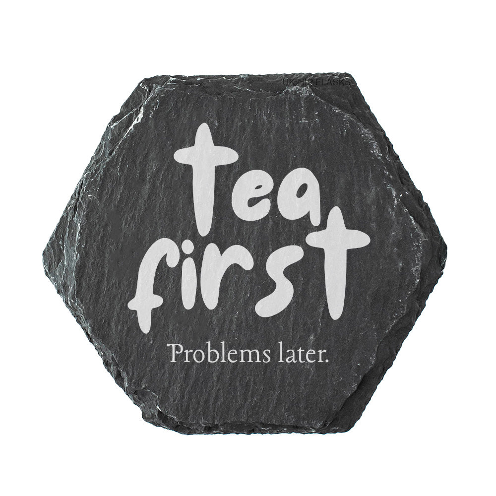 Hexagonal black slate coaster with 'Tea first, Problems later' text on a white background