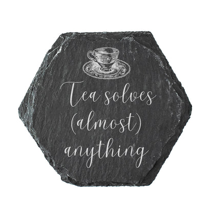 Hexagonal slate coaster with a tea cup illustration and text 'Tea solves (almost) anything' on a white background.
