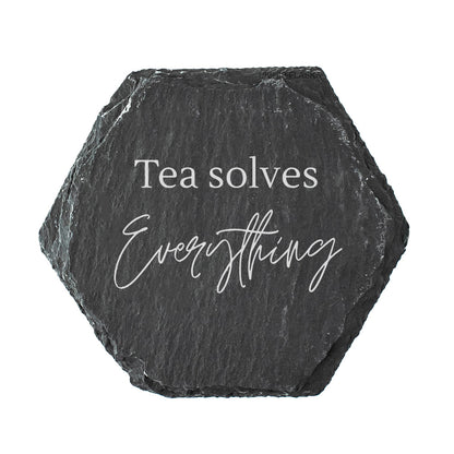 Hexagonal black slate coaster with 'Tea solves Everything' text on a white background