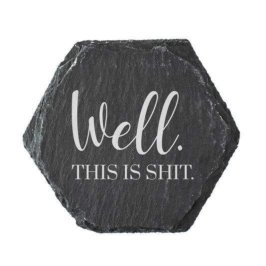 Hexagonal slate coaster with text 'Well. This is shit' on a white background