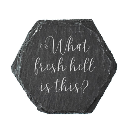 Hexagonal black slate coaster with white text 'What fresh hell is this?' on a white background
