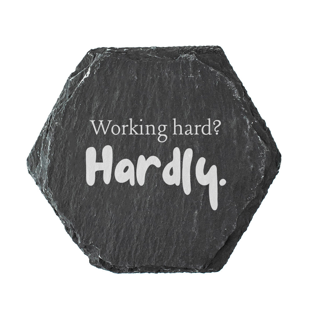 Hexagonal black slate coaster with 'Working hard? Hardly.' text on a white background