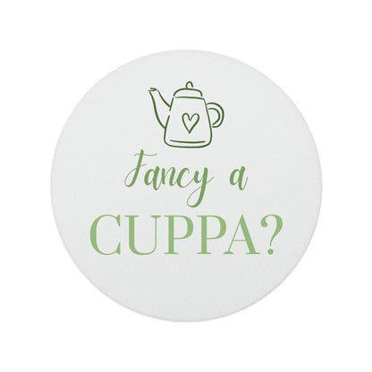 Round ceramic coaster featuring the cheerful quote "Fancy a cuppa?" in crisp green lettering. 