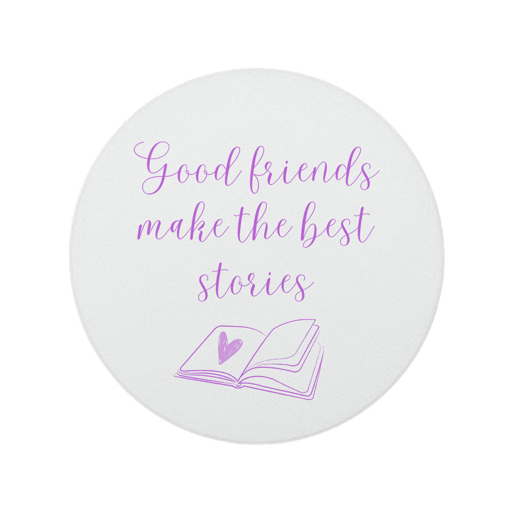 Round ceramic coaster featuring the friendship quote "Good friends make the best stories" in crisp purple lettering with a book illustration underneath.