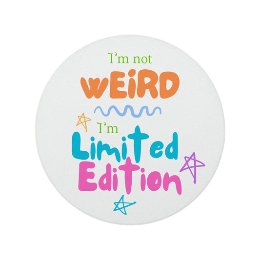 Round ceramic coaster featuring the quirky quote "I'm not weird, I'm limited edition" in colourful lettering.