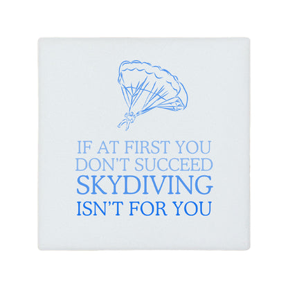 Square ceramic coaster featuring the funny quote "If at first you don't succeed, skydiving isn't for you" in crisp blue lettering with a parachute illustration.