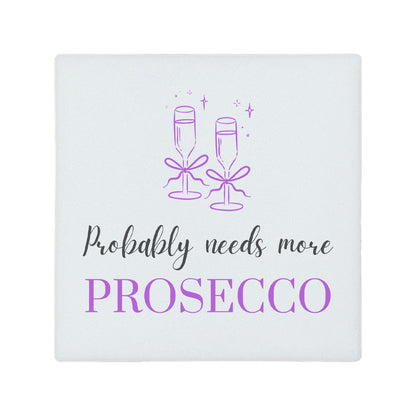 Square ceramic coaster featuring the funny quote "Probably needs more prosecco" in crisp grey and purple lettering with a prosecco glass illustration.