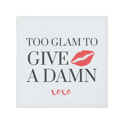 Square ceramic coaster featuring the witty quote "Too glam to give a damn" in grey text with a red illustrated lipstick print.
