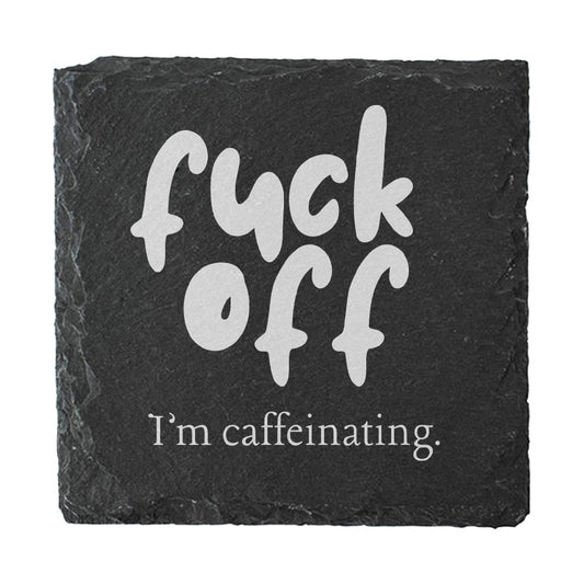 Slate coaster with white text 'fuck off I'm caffeinating' on a black background