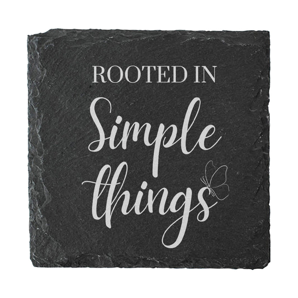 Black slate coaster with 'Rooted in Simple Things' text and butterfly design on a white background