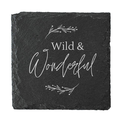 Black slate coaster with 'Wild & Wonderful' text and decorative elements on a white background