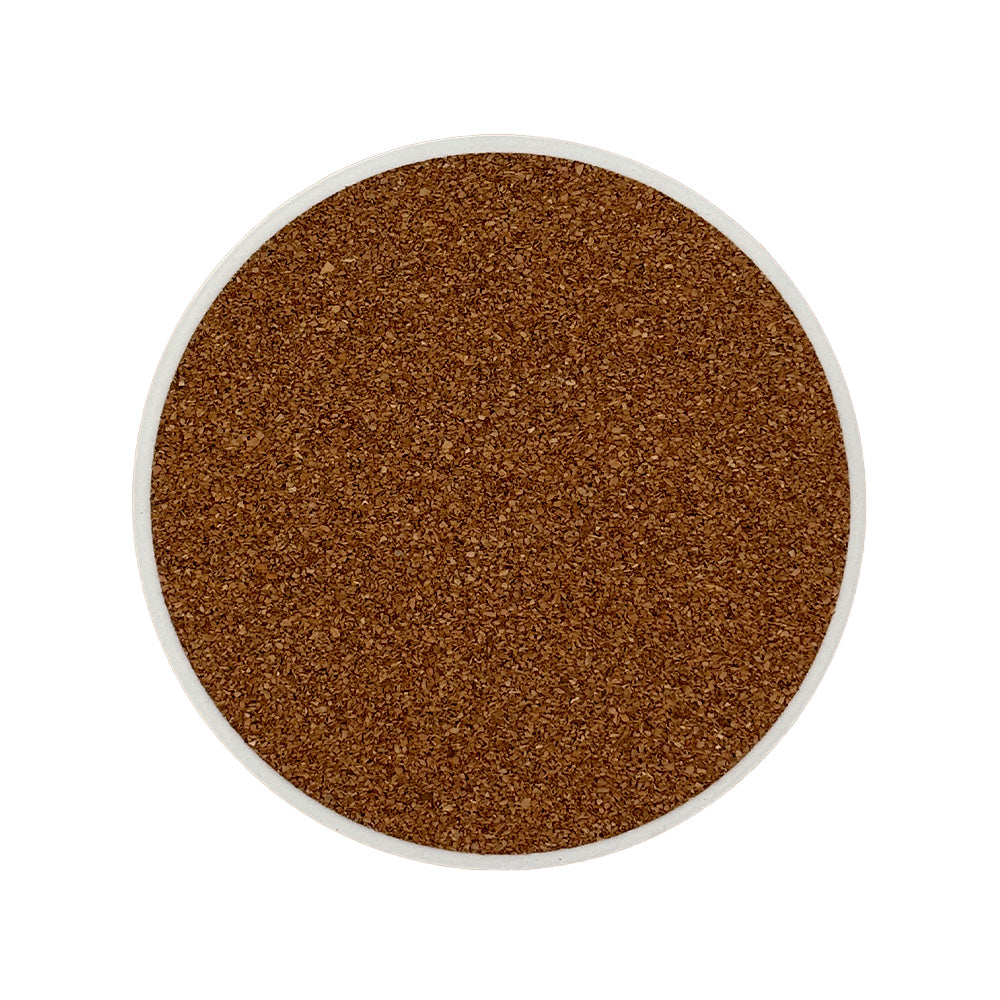 The back of a round ceramic coaster covered with cork to protect work surfaces.