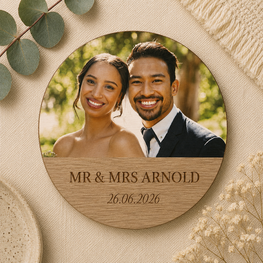 Round wooden plaque with a photo of a couple on their wedding day and personalised text and date on a textured beige background.