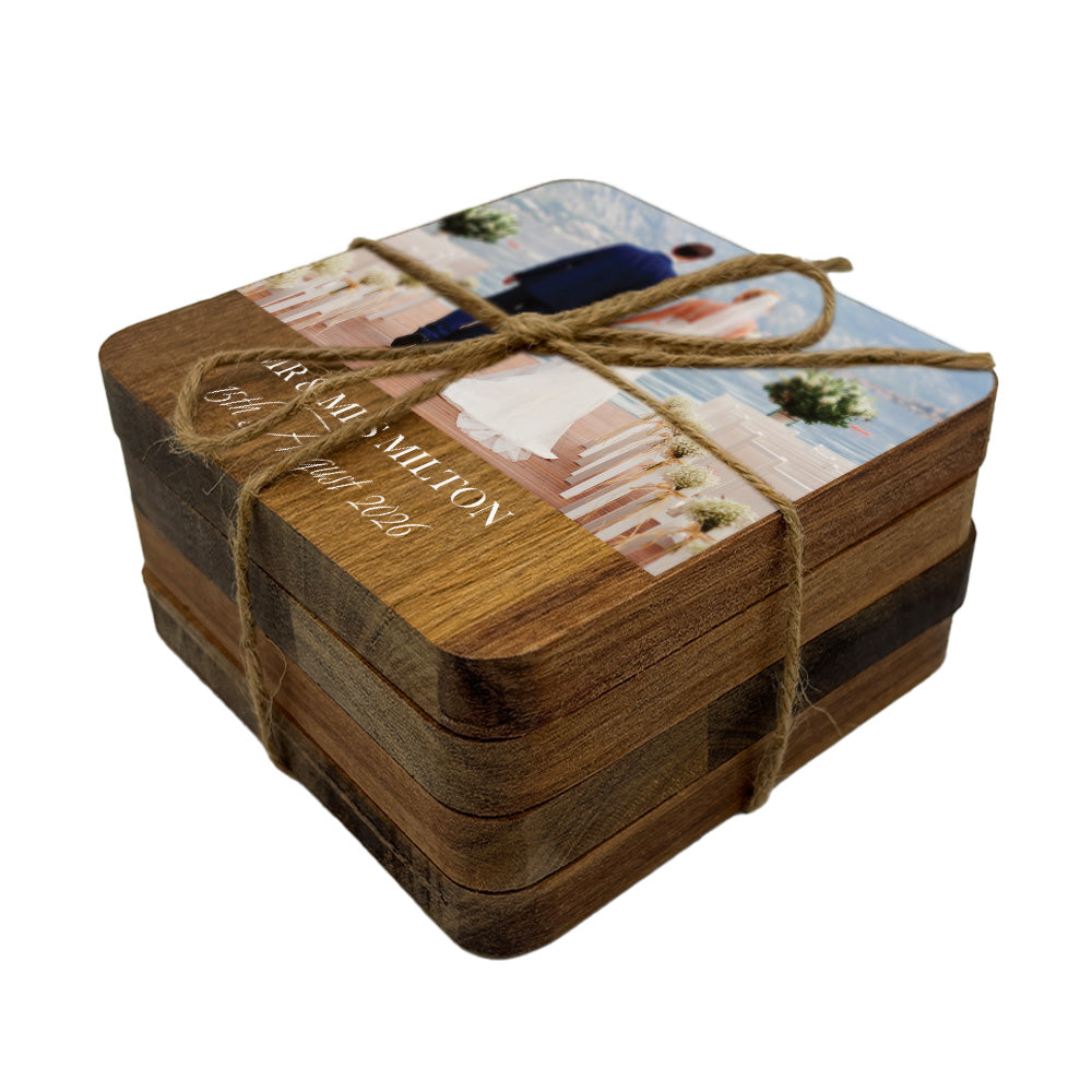 Set of wooden coasters with personalised wedding photo and text tied together with twine on a white background